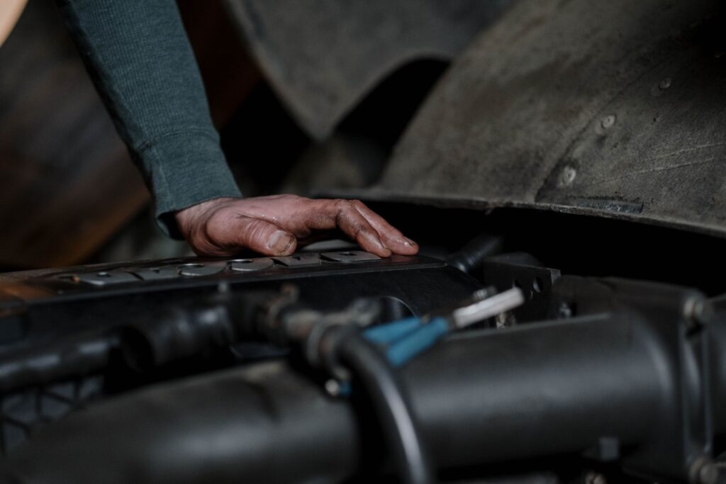 Mechanicien controleert de motor van een auto tijdens een onderhoudsbeurt in de garage