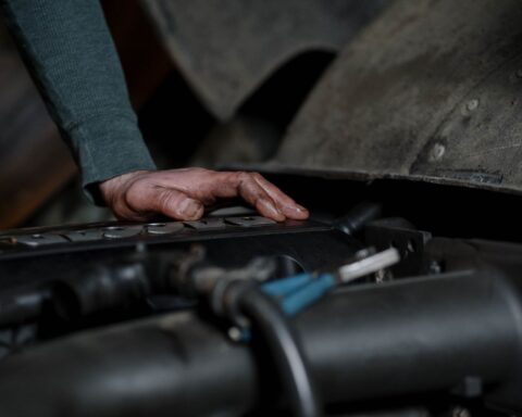 Mechanicien controleert de motor van een auto tijdens een onderhoudsbeurt in de garage